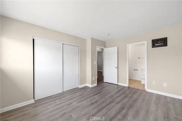 4137 Tiberon Dr, Oceanside, CA 92056 - unfurnished bedroom featuring wood finished floors, a closet, baseboards, and connected bathroom
