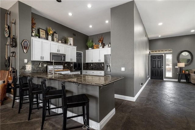 13946 Moqui Way, Corona, CA 92883 - kitchen with stainless steel appliances, a peninsula, recessed lighting, dark stone counters, and tasteful backsplash