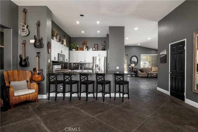 13946 Moqui Way, Corona, CA 92883 - kitchen featuring stainless steel fridge with ice dispenser, a peninsula, a kitchen bar, recessed lighting, and lofted ceiling