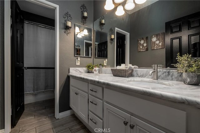 13946 Moqui Way, Corona, CA 92883 - full bathroom with double vanity, wood finished floors, a textured wall, baseboards, and a chandelier