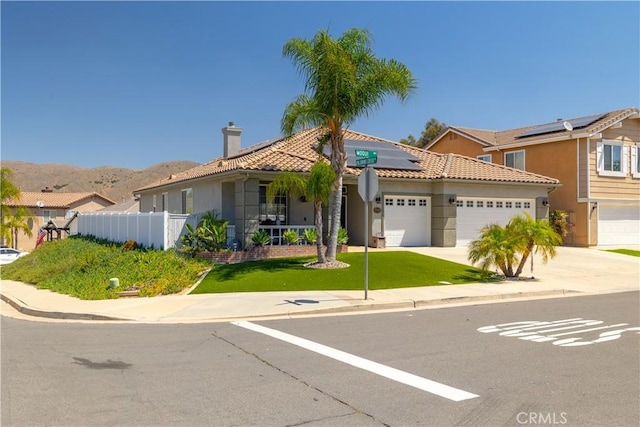 13946 Moqui Way, Corona, CA 92883 - view of front of house with solar panels, stucco siding, a garage, a tile roof, and concrete driveway