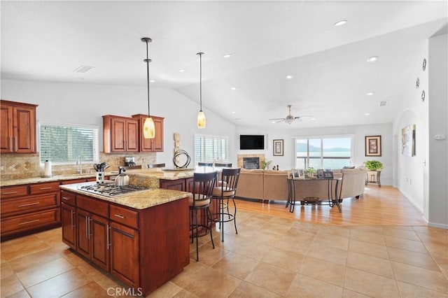2921 Crestview Dr, Clearlake, CA 95422 - kitchen with a breakfast bar area, open floor plan, ceiling fan, stainless steel gas cooktop, and plenty of natural light