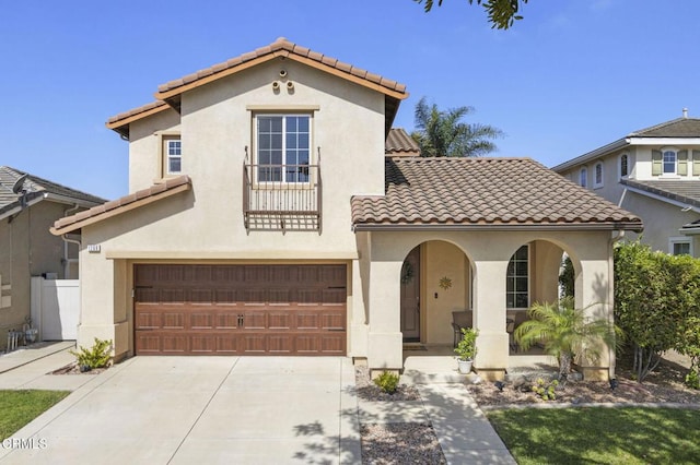 1269 Hacienda Dr, Oxnard, CA 93030 - mediterranean / spanish house featuring a porch, a tiled roof, an attached garage, stucco siding, and concrete driveway