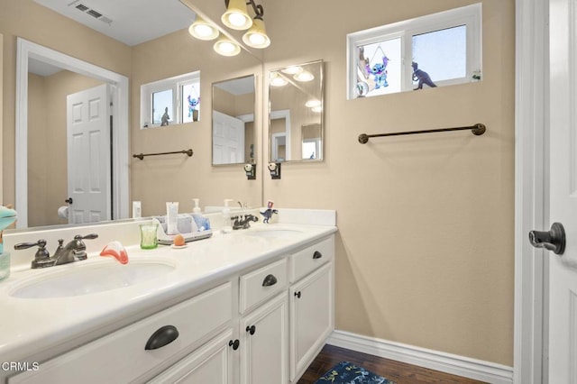 1269 Hacienda Dr, Oxnard, CA 93030 - bathroom with double vanity, plenty of natural light, baseboards, and wood finished floors