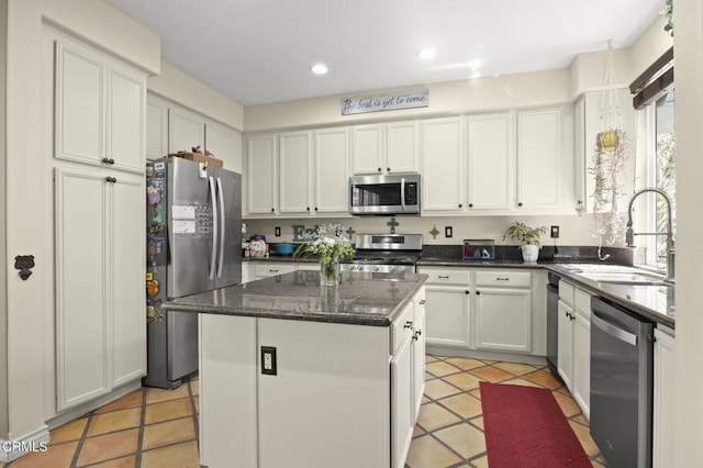 1269 Hacienda Dr, Oxnard, CA 93030 - kitchen featuring stainless steel appliances, a sink, a center island, white cabinetry, and light tile patterned floors