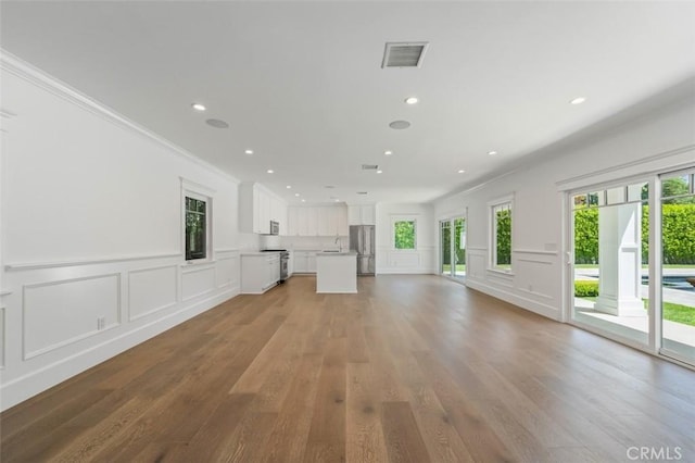 20701 Dumont St, Woodland Hills, CA 91364 - unfurnished living room featuring a decorative wall, plenty of natural light, crown molding, light wood-style floors, and recessed lighting