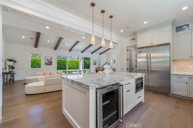 20701 Dumont St, Woodland Hills, CA 91364 - kitchen with built in appliances, wine cooler, open floor plan, dark wood-style floors, and light stone countertops