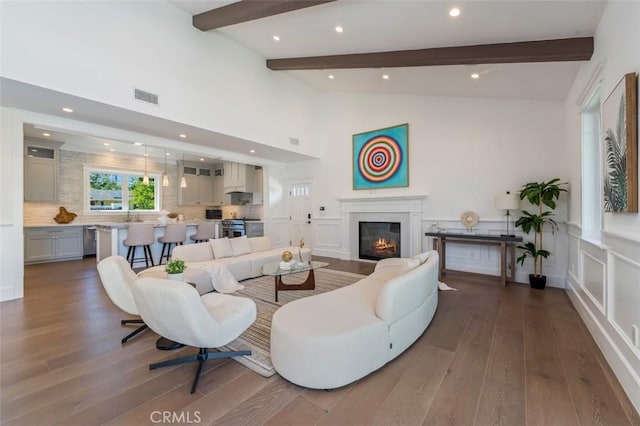 20701 Dumont St, Woodland Hills, CA 91364 - living area with wood finished floors, a glass covered fireplace, recessed lighting, wainscoting, and a decorative wall