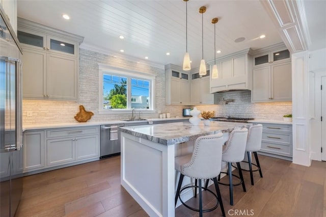 20701 Dumont St, Woodland Hills, CA 91364 - kitchen featuring appliances with stainless steel finishes, dark wood-style flooring, a center island, a sink, and backsplash