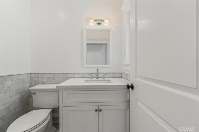 20701 Dumont St, Woodland Hills, CA 91364 - half bath with vanity, toilet, wainscoting, and tile walls
