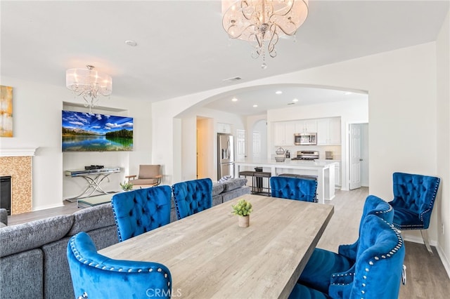 84020 Colibri Ct, Indio, CA 92203 - dining area featuring a chandelier, arched walkways, light wood finished floors, baseboards, and recessed lighting