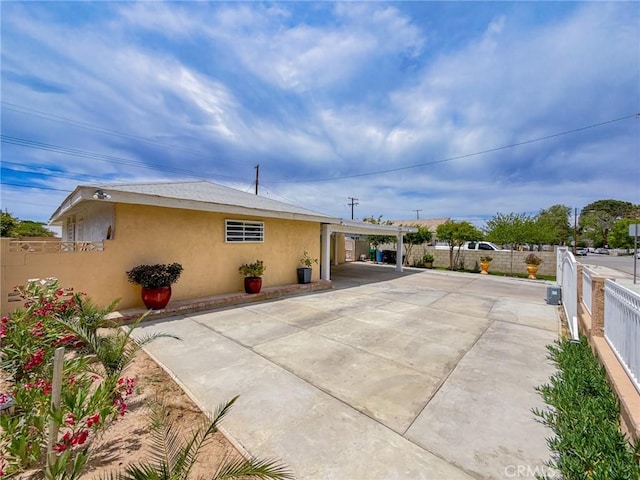 45431 Sancroft Ave, Lancaster, CA 93535 - rear view of house featuring stucco siding, driveway, and an attached carport