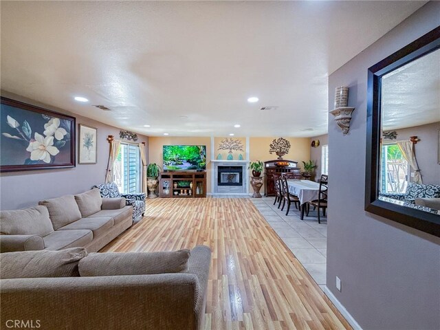 45431 Sancroft Ave, Lancaster, CA 93535 - living room featuring light wood-style flooring, recessed lighting, and a glass covered fireplace