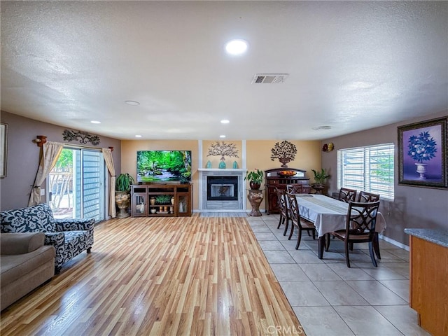 45431 Sancroft Ave, Lancaster, CA 93535 - living room featuring healthy amount of natural light, baseboards, a glass covered fireplace, recessed lighting, and a textured ceiling