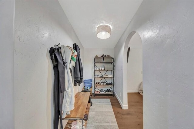 306 Avenida Monterey, San Clemente, CA 92672 - hallway featuring arched walkways, wood finished floors, a textured wall, and baseboards