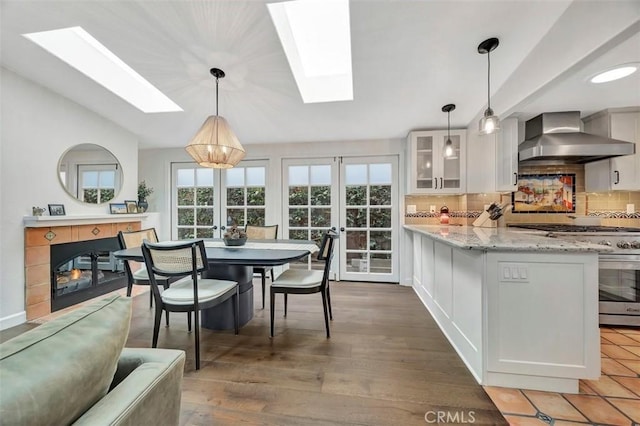 306 Avenida Monterey, San Clemente, CA 92672 - kitchen with a skylight, wall chimney range hood, stainless steel range, and healthy amount of natural light