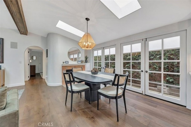 306 Avenida Monterey, San Clemente, CA 92672 - dining area featuring a skylight, a chandelier, arched walkways, wood finished floors, and lofted ceiling