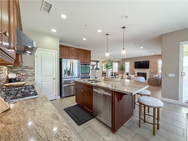 6184 Lafayette St, Chino, CA 91710 - kitchen featuring stainless steel appliances, range hood, a sink, a fireplace, and decorative backsplash