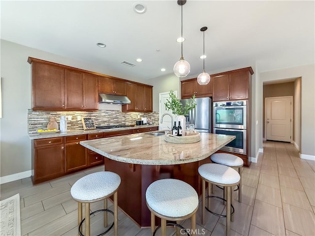 6184 Lafayette St, Chino, CA 91710 - kitchen with stainless steel appliances, under cabinet range hood, a sink, decorative backsplash, and baseboards