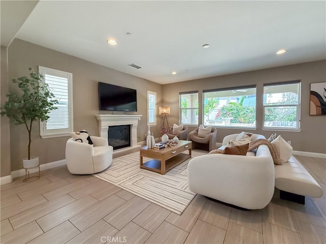 6184 Lafayette St, Chino, CA 91710 - living room with plenty of natural light, wood tiled floors, a glass covered fireplace, and recessed lighting