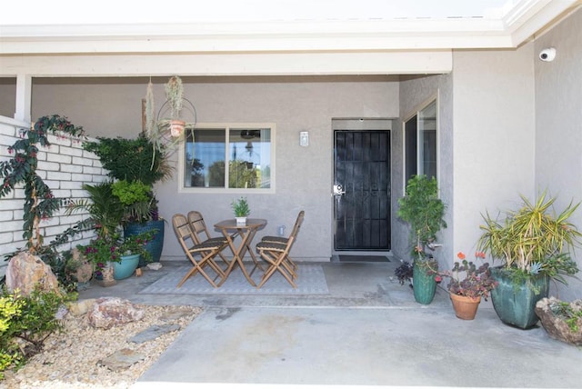 3625 Vista Oceana Unit 18, Oceanside, CA 92057 - doorway to property with a patio area, stucco siding, a surveillance system, and outdoor dining area