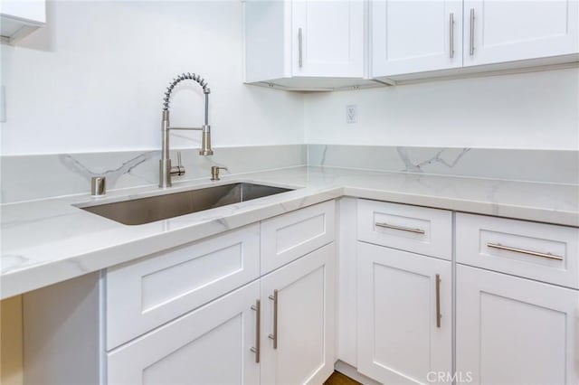 22016 Schoolcraft St, Canoga Park, CA 91303 - kitchen with a sink, white cabinetry, and light stone countertops