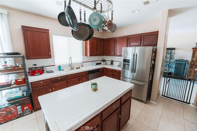 15193 Arcadian St, Adelanto, CA 92301 - kitchen featuring appliances with stainless steel finishes, tile countertops, a sink, light tile patterned floors, and a kitchen island