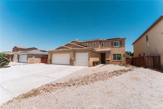 15193 Arcadian St, Adelanto, CA 92301 - view of front facade with stucco siding, a garage, roof mounted solar panels, concrete driveway, and stone siding