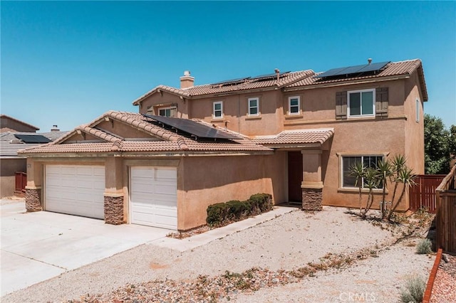 15193 Arcadian St, Adelanto, CA 92301 - view of front of house with roof mounted solar panels, an attached garage, driveway, and stucco siding
