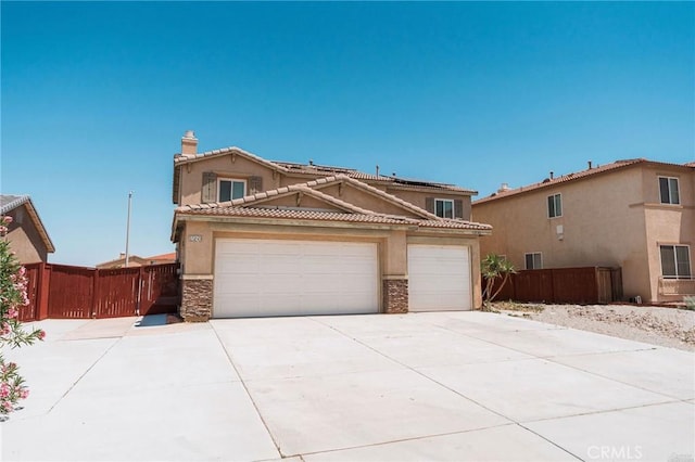 15193 Arcadian St, Adelanto, CA 92301 - view of front facade featuring concrete driveway, a garage, solar panels, stucco siding, and stone siding
