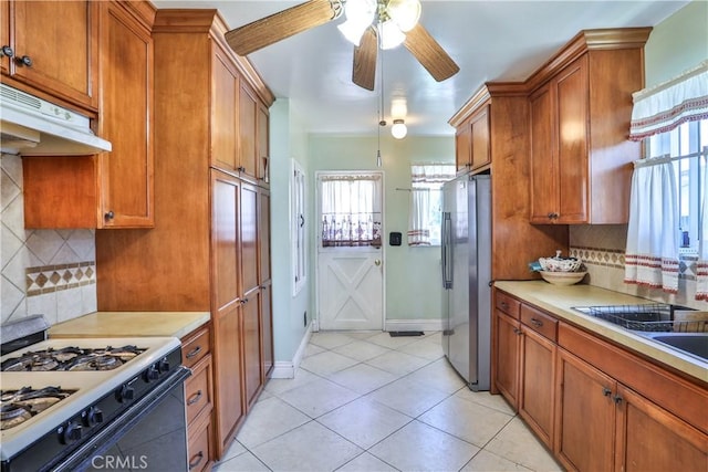 1706 James Pl, Pomona, CA 91767 - kitchen with gas range, freestanding refrigerator, brown cabinets, ceiling fan, and light countertops
