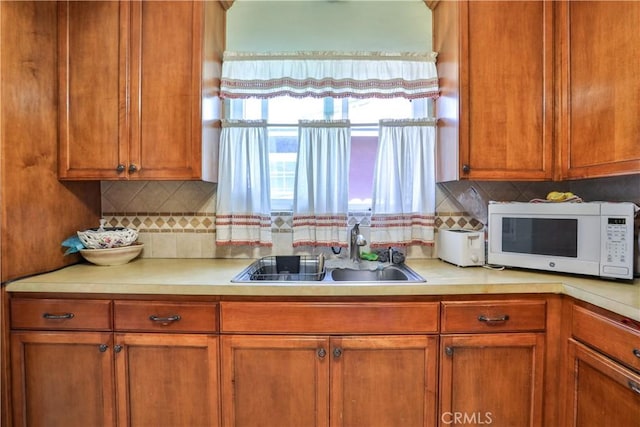 1706 James Pl, Pomona, CA 91767 - kitchen featuring white microwave, a sink, light countertops, and brown cabinets