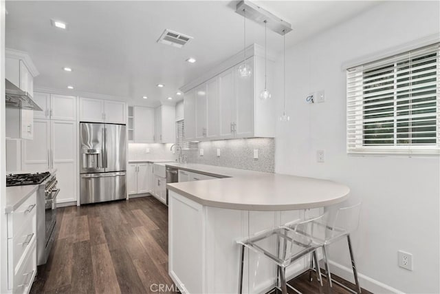 18653 Burbank Blvd Unit 2, Tarzana, CA 91356 - kitchen featuring appliances with stainless steel finishes, a peninsula, dark wood-style floors, white cabinetry, and recessed lighting