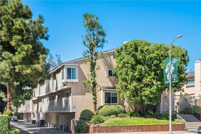 18653 Burbank Blvd Unit 2, Tarzana, CA 91356 - view of building exterior featuring an attached garage, stairway, and central AC
