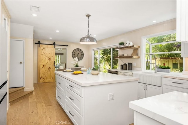 29422 Modjeska Canyon Rd, Modjeska Canyon, CA 92676 - kitchen featuring a barn door, a center island, white cabinetry, light wood finished floors, and plenty of natural light