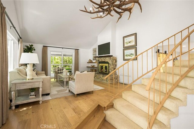 29422 Modjeska Canyon Rd, Modjeska Canyon, CA 92676 - living room with stairway, high vaulted ceiling, a chandelier, a fireplace, and wood finished floors