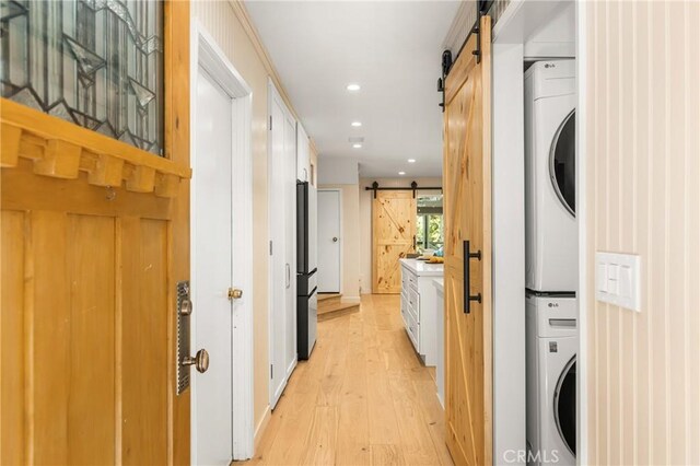29422 Modjeska Canyon Rd, Modjeska Canyon, CA 92676 - washroom with a barn door, stacked washer / drying machine, light wood-style floors, and recessed lighting