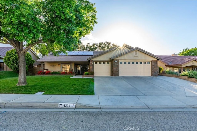 42311 Camden Way, Lancaster, CA 93536 - ranch-style house with a garage, roof mounted solar panels, a front lawn, driveway, and stucco siding