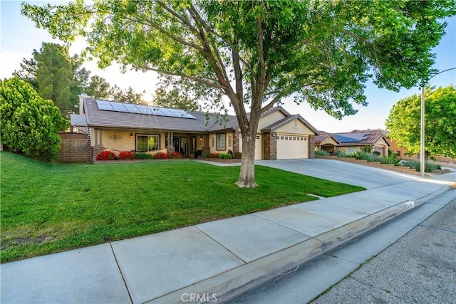 42311 Camden Way, Lancaster, CA 93536 - ranch-style house with concrete driveway, roof mounted solar panels, an attached garage, a front yard, and stucco siding