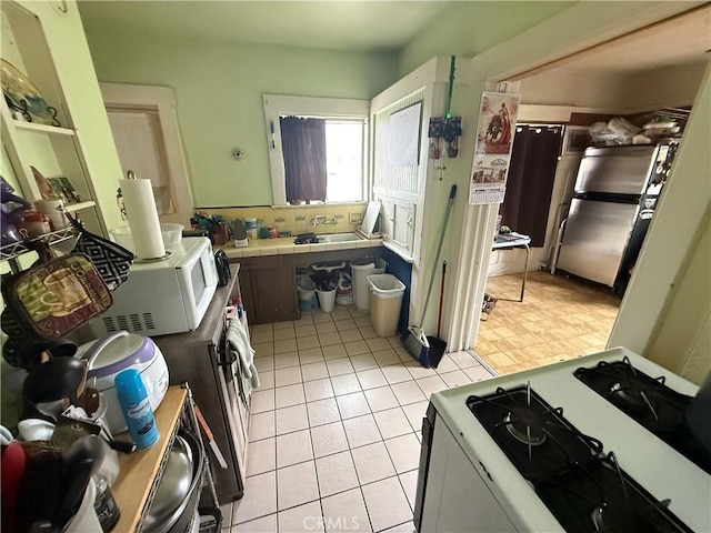 415417 Euclid Ave, Los Angeles, CA 90063 - kitchen featuring white appliances, tile counters, a sink, and light tile patterned floors