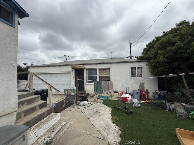 415417 Euclid Ave, Los Angeles, CA 90063 - rear view of house with a garage, stucco siding, and a lawn