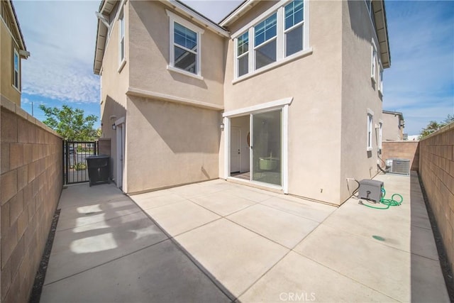 16725 Petrus Ln, Fontana, CA 92336 - rear view of house featuring stucco siding, a gate, a fenced backyard, central air condition unit, and a patio area