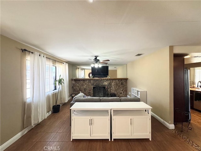 7425 I Ave, Hesperia, CA 92345 - bedroom featuring a stone fireplace, baseboards, ceiling fan, and dark wood-type flooring