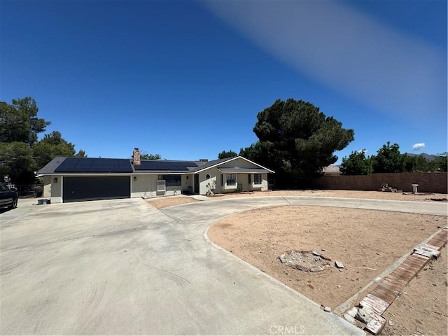 7425 I Ave, Hesperia, CA 92345 - ranch-style house with curved driveway, solar panels, an attached garage, and a chimney
