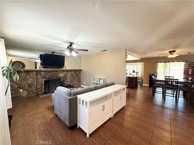7425 I Ave, Hesperia, CA 92345 - living room with a ceiling fan, a stone fireplace, and dark tile patterned floors