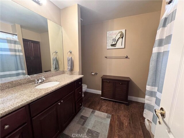 7425 I Ave, Hesperia, CA 92345 - bathroom featuring wood finished floors, vanity, baseboards, and toilet