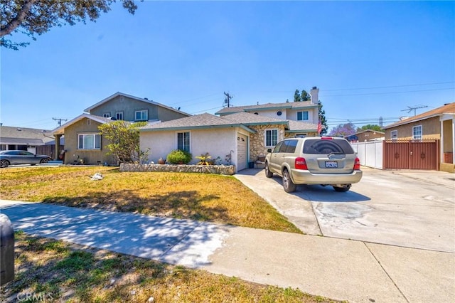 9419 Bartley Ave, Santa Fe Springs, CA 90670 - view of front of property featuring driveway, a garage, stucco siding, stone siding, and a gate
