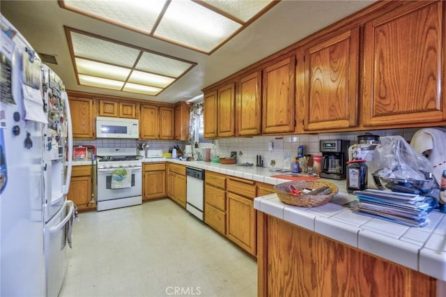 9419 Bartley Ave, Santa Fe Springs, CA 90670 - kitchen featuring white appliances, brown cabinets, tasteful backsplash, and tile countertops