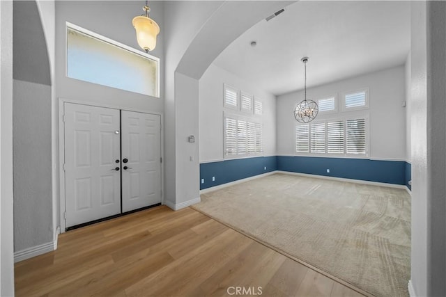 8840 Greenlawn St, Riverside, CA 92508 - foyer entrance with arched walkways, a chandelier, wood finished floors, and baseboards