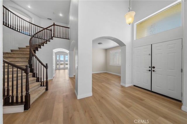 8840 Greenlawn St, Riverside, CA 92508 - foyer with arched walkways, a towering ceiling, baseboards, light wood finished floors, and stairs